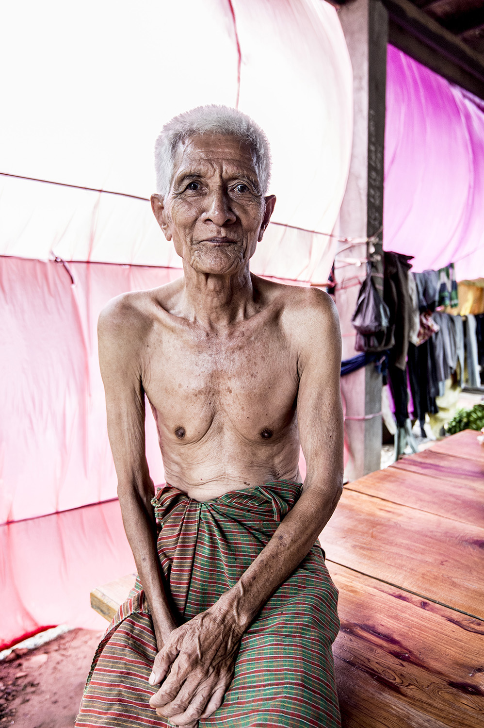 image of AARONTAIT COPYRIGHTED 2014 303 TRAVEL PHOTOGRAPHER ASIA REPORTAGE EDITORIAL STORY HUMANS LIFE EARTH TRAVELER EXPLORE CULTURE PEOPLE COUNTRY NATIONALITY DOCUMENTARY CAMBODIA VETEREN ELDER MAN PINK PORT
