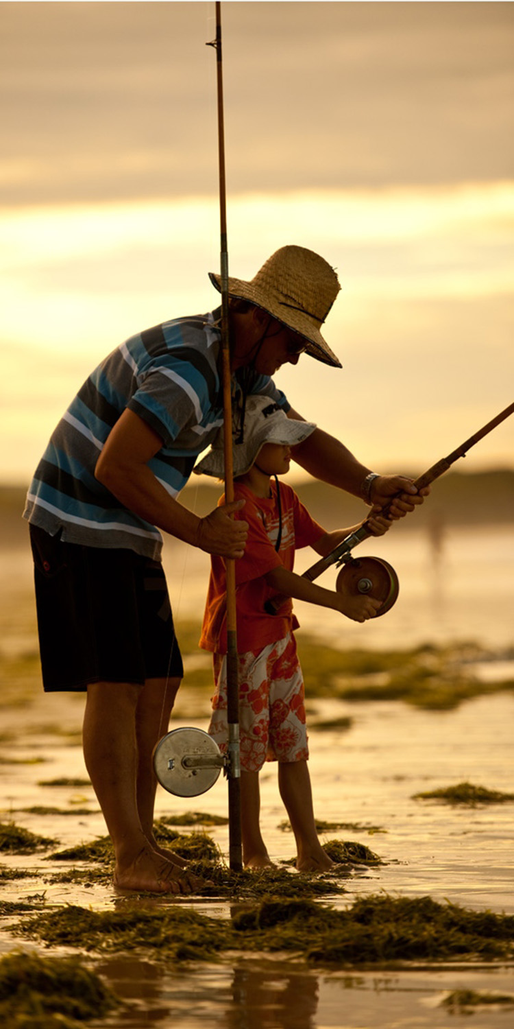 image of AARONTAIT COPYRIGHTED 2014 146  ADVERTISING LIFESTYLE BEACH ISLAND LIFE FATHER SON NATURAL LIGHT WARM LEARNING TO FISH FISHING SURF FISHING ALVEY SURF REEL OLD SCHOOL TRADITION NATURE