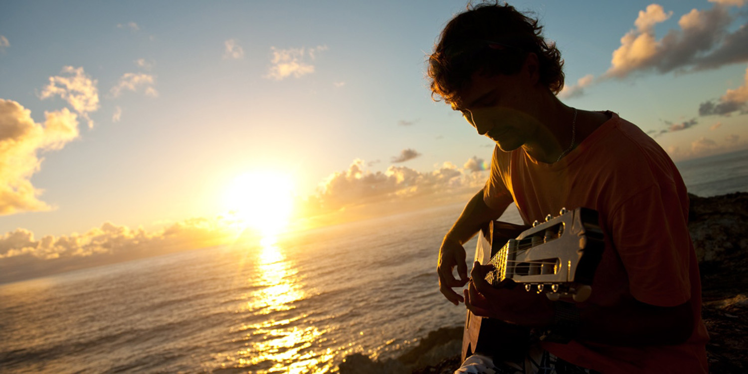 image of AARONTAIT COPYRIGHTED 2014 155 ADVERTISING LIFESTYLE BEACH ISLAND LIFE GUITARIST SUNRISE IN THE MOMENT WARM NATURAL LIGHT 