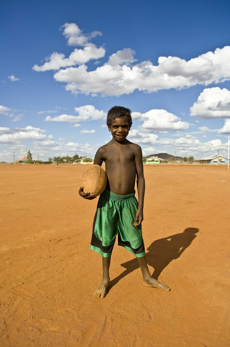 image of AARONTAIT-COPYRIGHTED-2014-5362 EDITORIAL DOCUMENTARY PHOTOGRAPHER PAPUNYA NORTHERN TERRITORY AUSTRALIA LANDSCAPE LIFE PEOPLE ART INDIGENOUS PINTUPI LURITJA PAPUNYA TULA FOOTY AFL PORTRAIT RED GREEN B